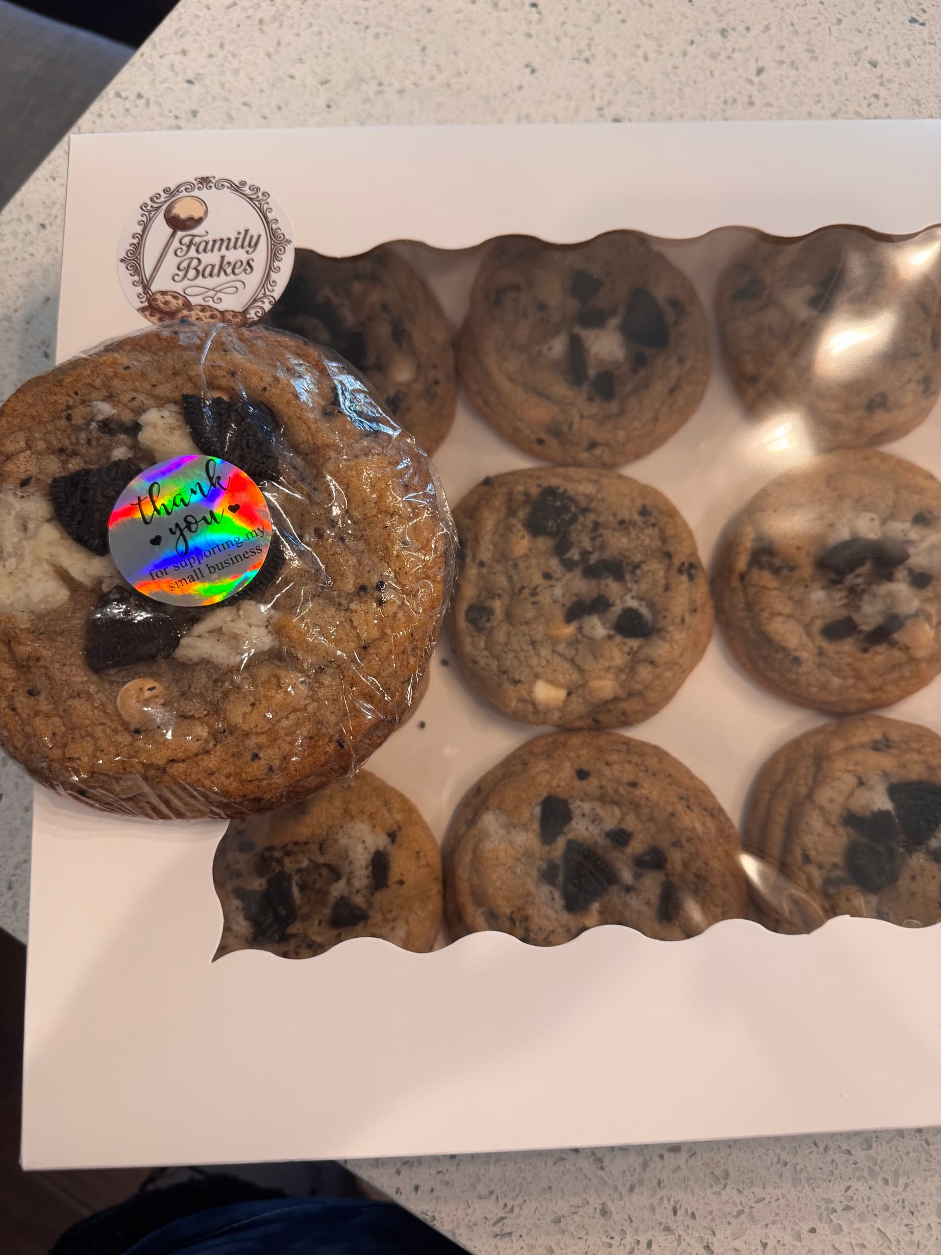 Caramel cookies topped with melted chocolate and mini Twix bars, boxed.