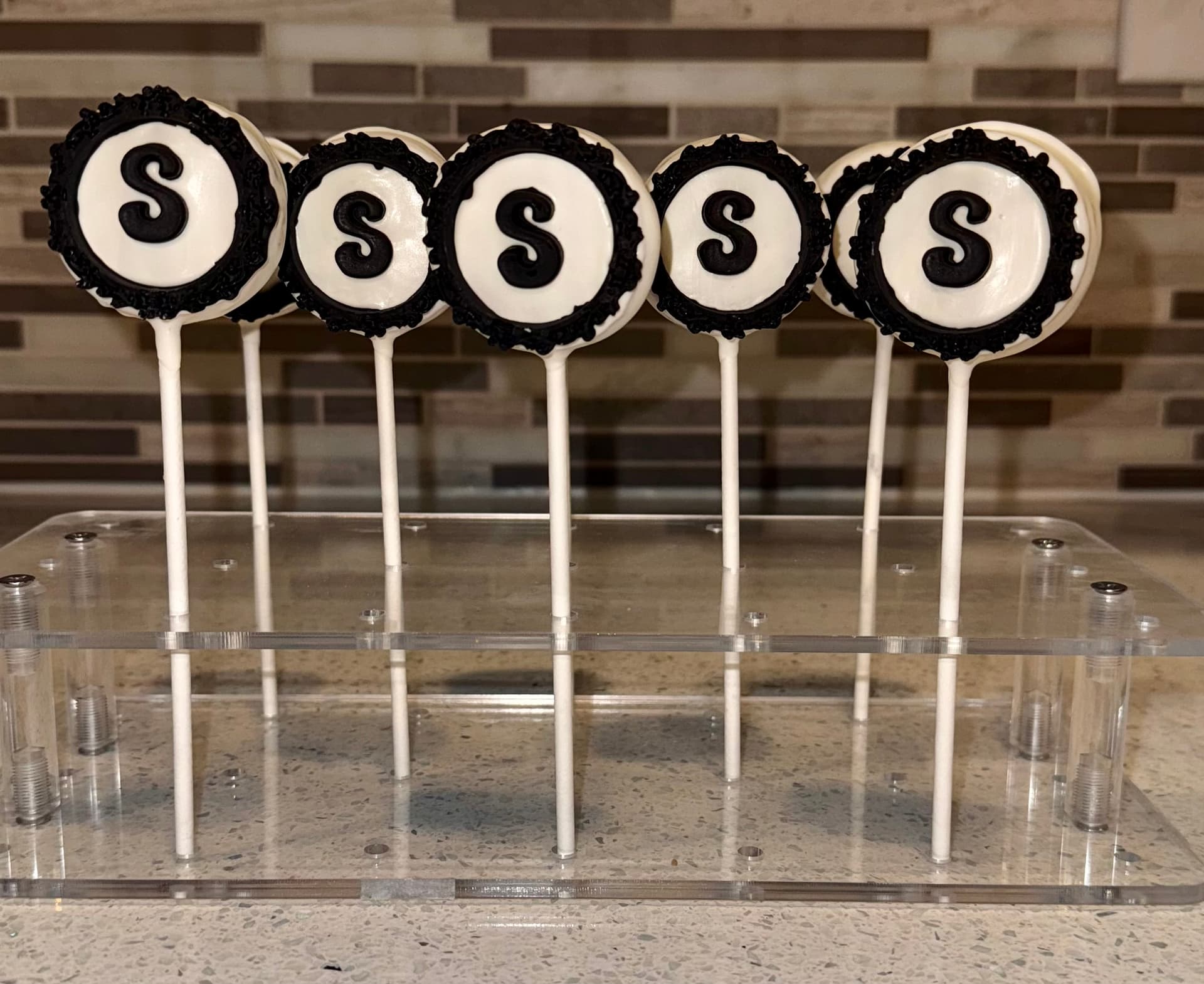 Pirate-themed cake pops with a treasure map, ship, skull and crossbones and treasure chest, boxed with scattered chocolate coins.