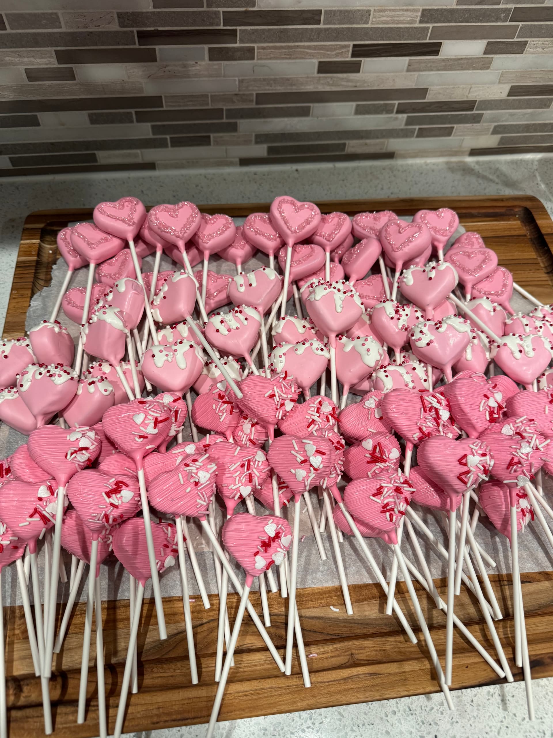 Woodland-animal cake pops in pale blue, with a bear, fox, hedgehog and owl among painted trees, on a stand.