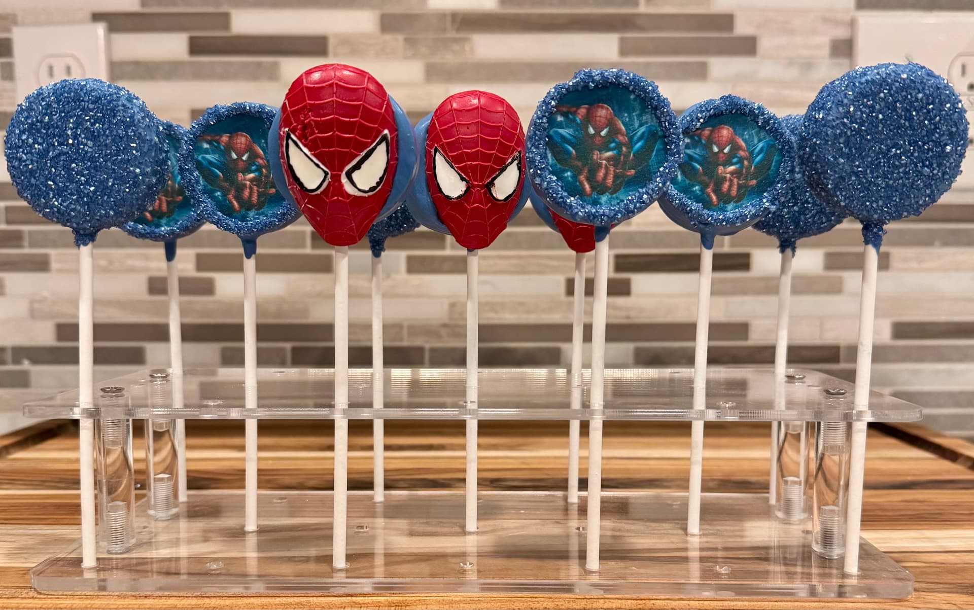 Cake pops decorated with a red and blue Spider-Man design.