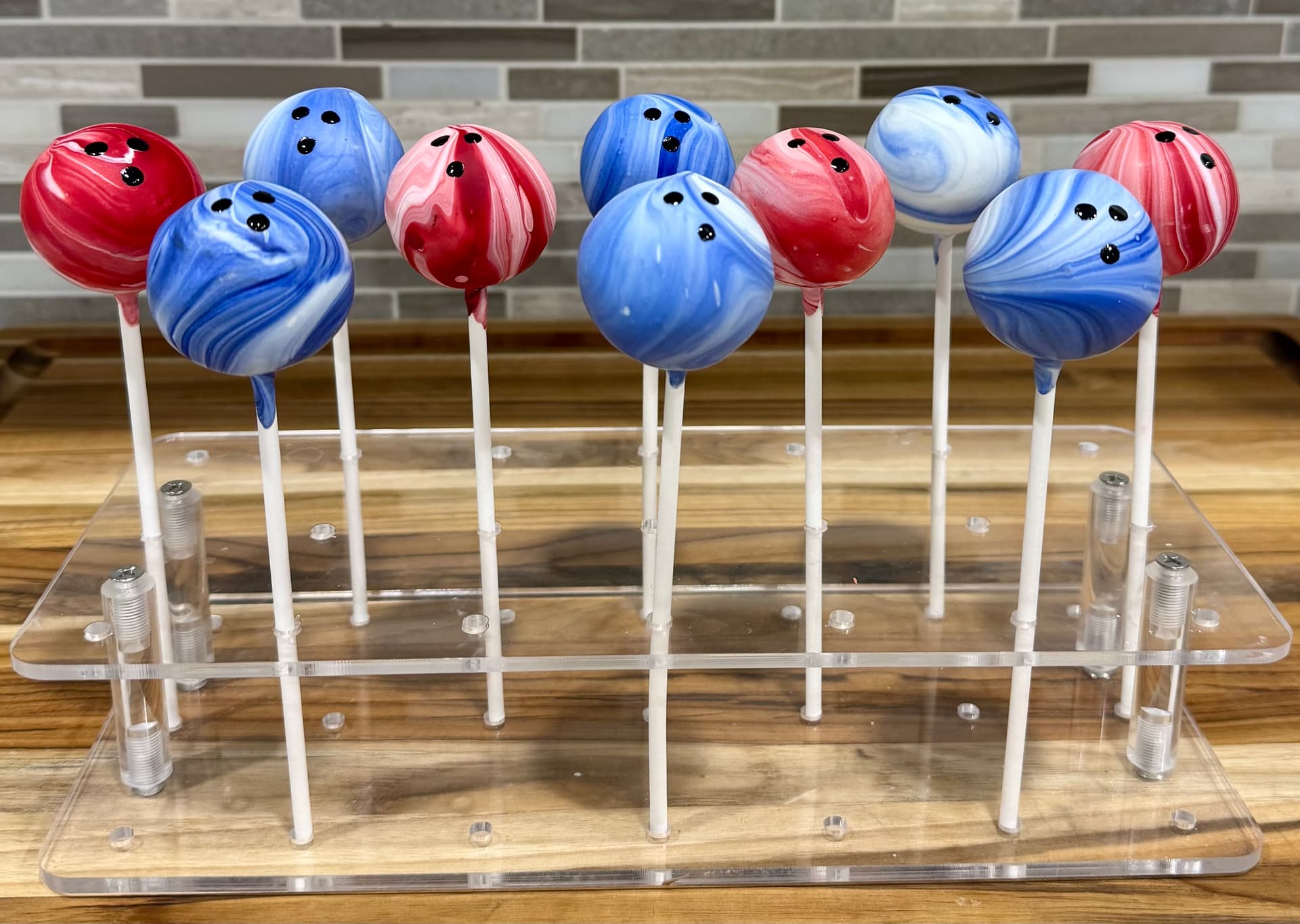 A marbled cake pop designed to look like a bowling ball.