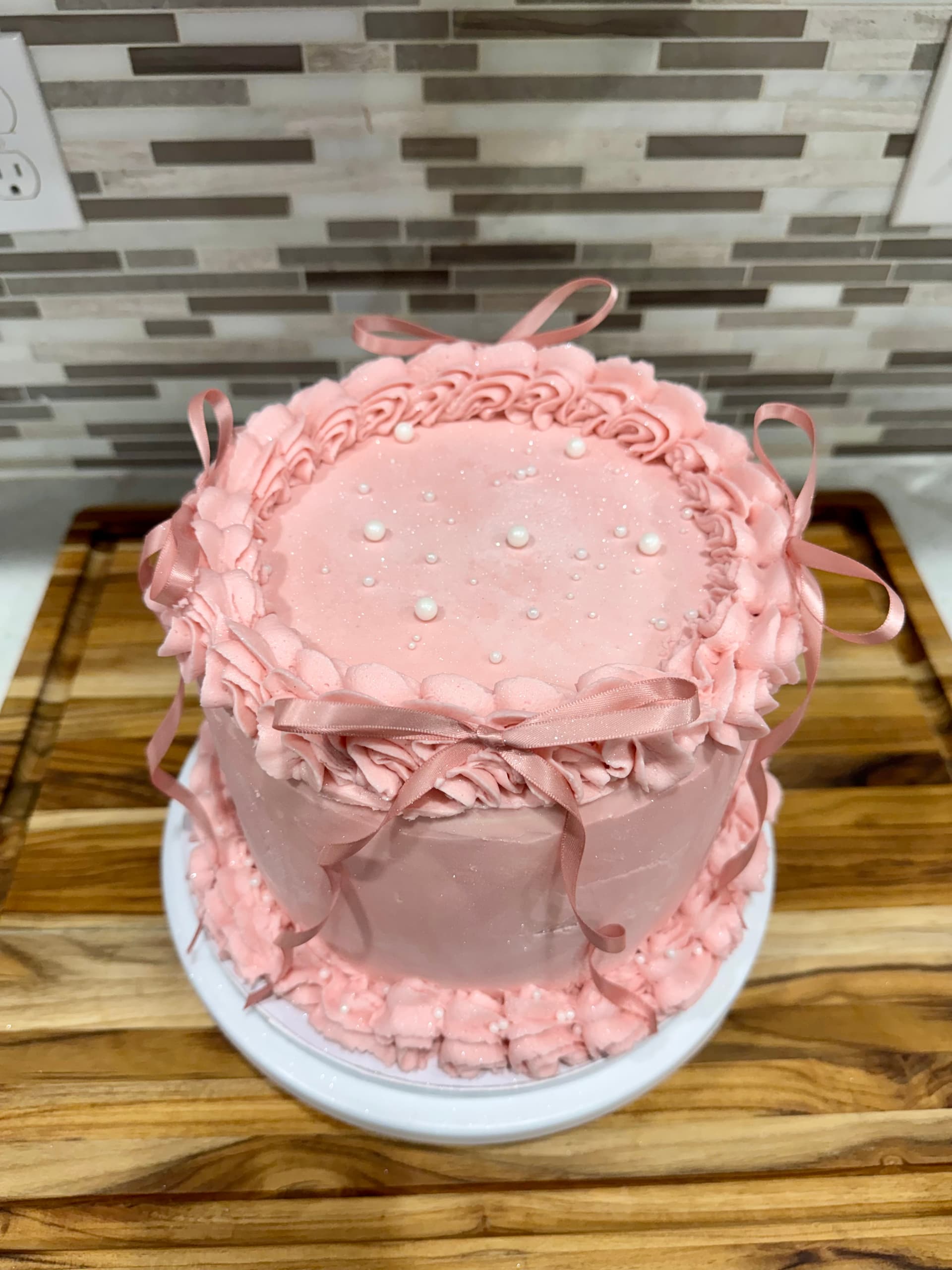 A cake finished with pink ombre buttercream.