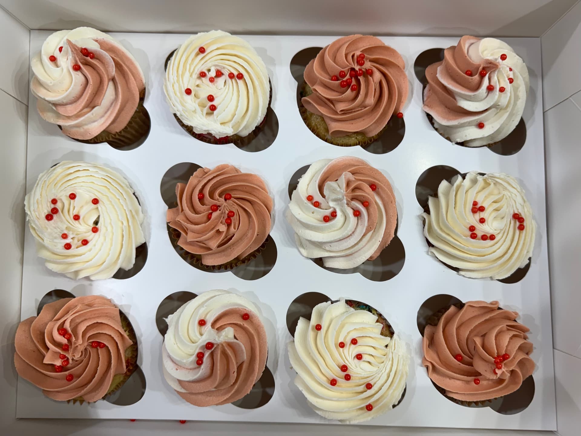 Cupcakes topped with red sprinkles.