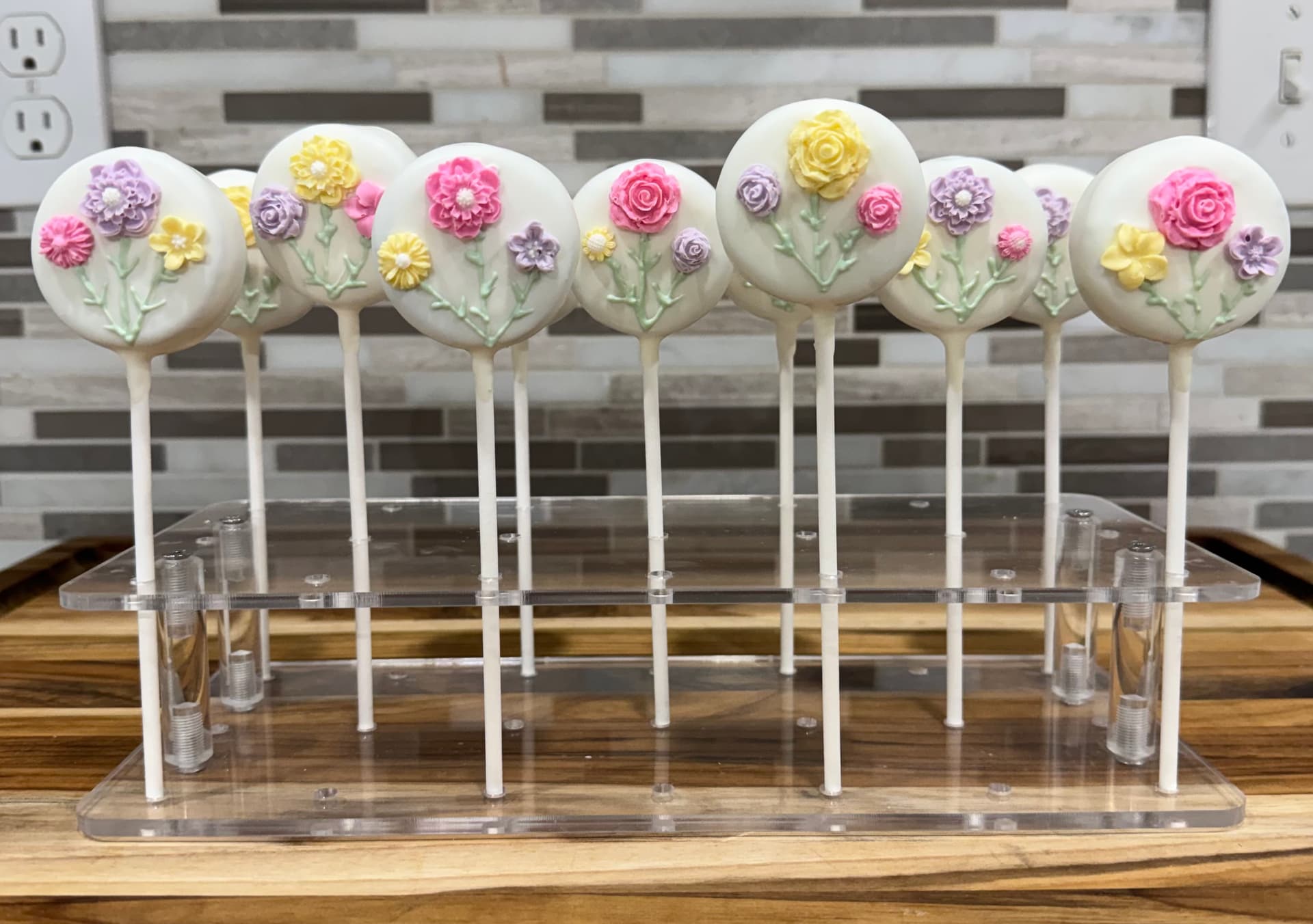 Cake pops with a white floral design.