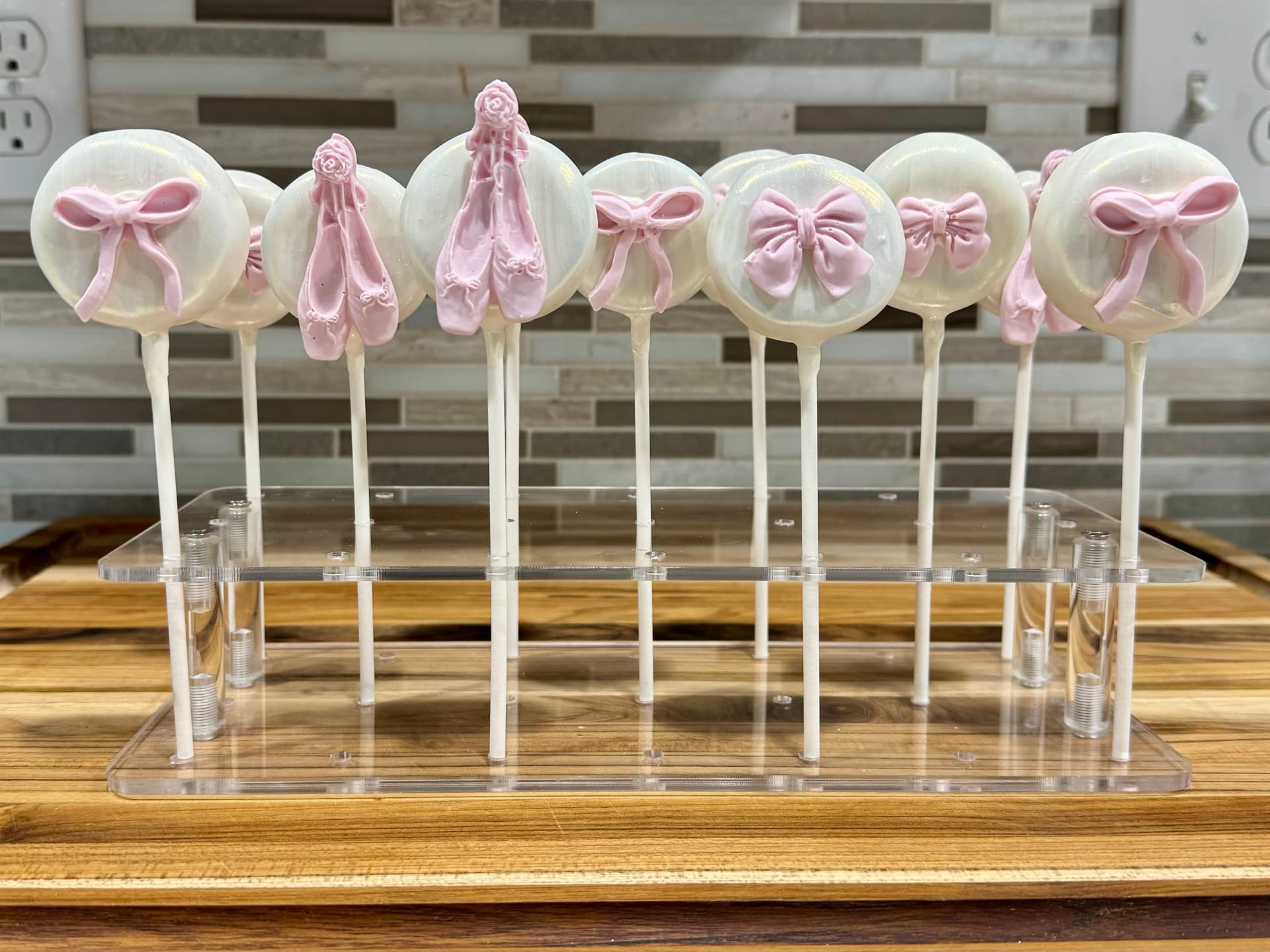 Cake pops decorated with a ballet bow design.
